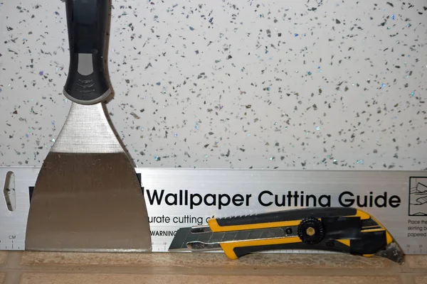 Wallpapering tools against a metal fleck patterned wall. — Stock Photo, Image
