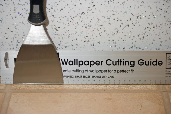 Wallpapering hand tools against a metal fleck pattern wall. — Stock Photo, Image