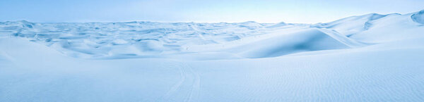 Big snow and ice dunes panorama with tire marks. Arctic Snowball Earth.