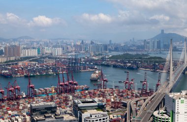 Container port cranes load cargo vessels in Hong Kong harbour