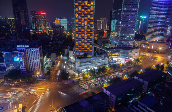 Sichuan province capital Chengdu with heavy traffic on wide illuminated highways among modern buildings at dark night in China