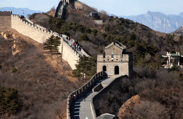 Tourists walk on Chinese Great Wall past tower — Stock Fotó