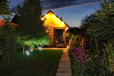 MOSCOW REJON, RUSSIA Alacakaranlık 'ta aydınlatılmış Rus Dacha. Küçük ahşap misafir evi. Gece vakti ladin ağaçlarıyla dolu. Güzel bir sonbahar sabahı, alacakaranlık gökyüzüyle..