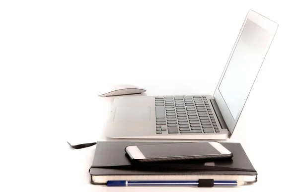 Spazio di lavoro con notebook / computer portatile, diario, cellulare e mouse sulla superficie bianca pulita del desktop — Foto Stock