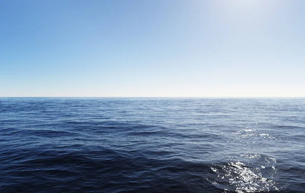 Duidelijke blauwe hemel boven golfde oceaanwater met zonlicht reflectie — Stockfoto
