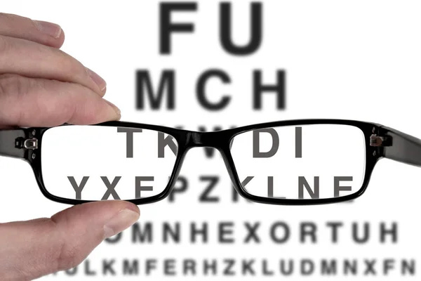 Male hand holding black spectacles frame for vision eye examination test — Stock Photo, Image