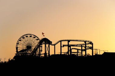 santa monica pier eğlence parkı ile dönme dolap batımında silüeti