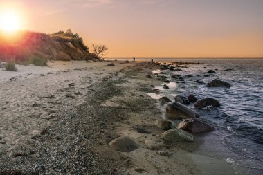 Fehmarn Adası günbatımı sırasında Almanya Baltık Denizi sahilinde doğal plaj