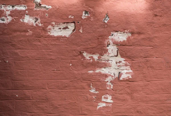 Pared de ladrillo pintado rojo con yeso pelado agrietado y fondo de pintura — Foto de Stock