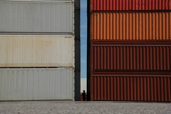 Silhouette of person standing between stacks of cargo containers — Stock Photo, Image