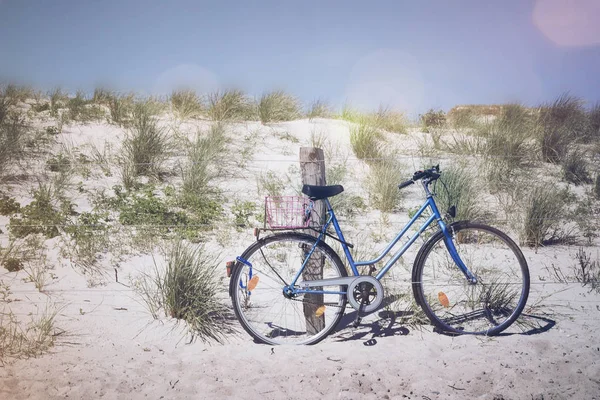 Vélo garé contre un poteau de clôture en bois dans les dunes couvertes d'herbe à la plage de la mer Baltique — Photo