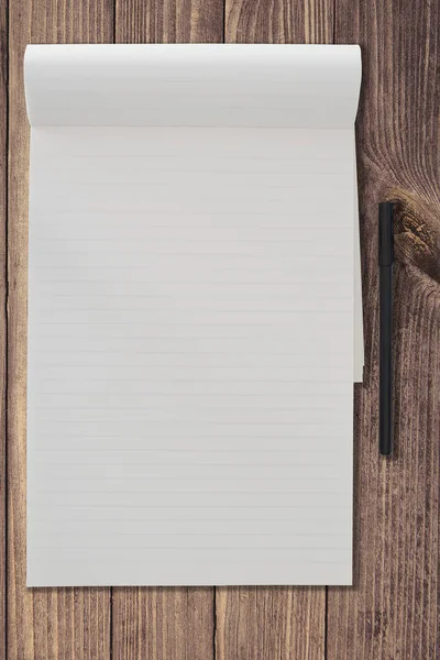 Vista superior do bloco de notas governado em branco e caneta lado a lado no modelo de fundo de mesa de madeira rústica — Fotografia de Stock
