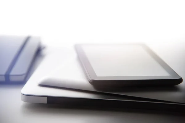 Computer portatile, tablet e telefono cellulare oltre al diario notebook sulla superficie del desktop bianco — Foto Stock