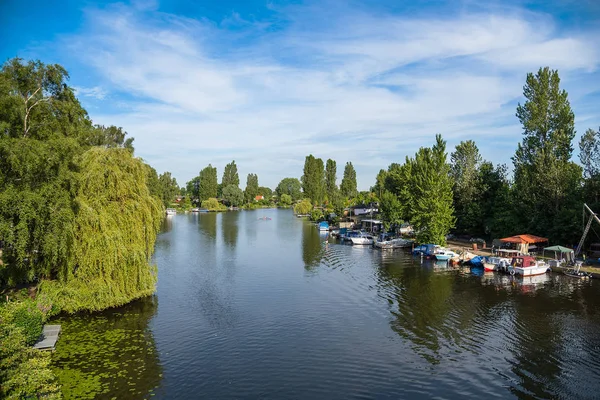 Fluss in Hamburg, Deutschland mit Booten und saftig grüner Vegetation auf beiden Seiten unter blauem Himmel — Stockfoto