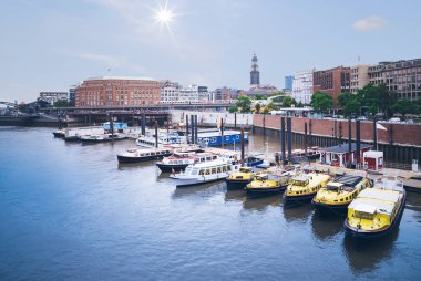 Hamburg liman Baumwall station ile arka planda Sankt Michaelis Kilisesi'nin çan kulesi yakınındaki gezi tekneleri