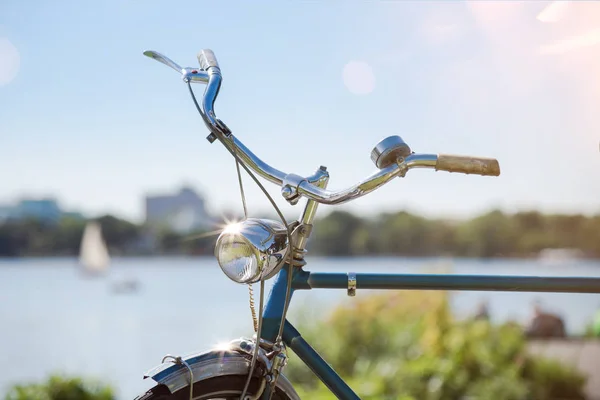 Vista parcial de la bicicleta azul vintage con manillar y luz bajo el cielo azul de verano —  Fotos de Stock