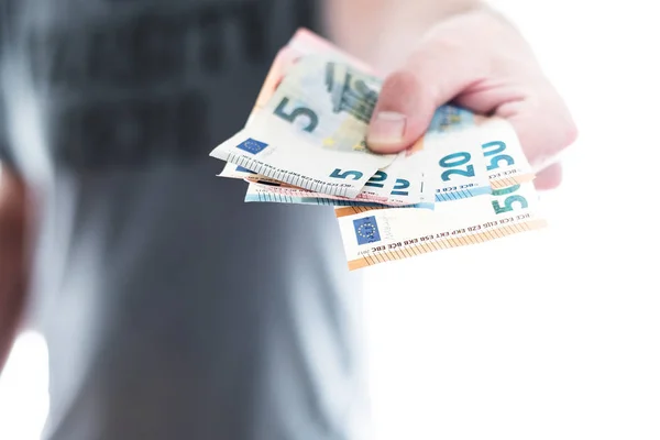Hand einer männlichen Person übergibt ein paar verschiedene Euro-Scheine — Stockfoto