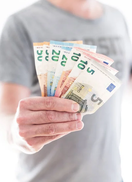 Hand einer männlichen Person übergibt ein paar verschiedene Euro-Scheine — Stockfoto