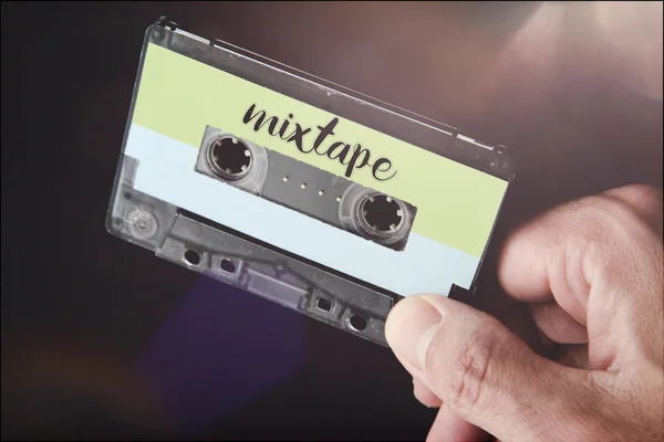 Mão segurando uma fita de áudio dos anos 80 cassete rotulado mixtape — Fotografia de Stock