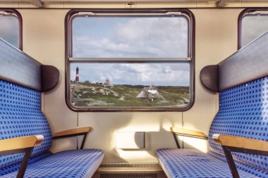 empty train compartment with view on quaint landscape through window clipart