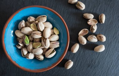 el tahtası yüzeyi bir kasede kavrulmuş Antep fıstığı