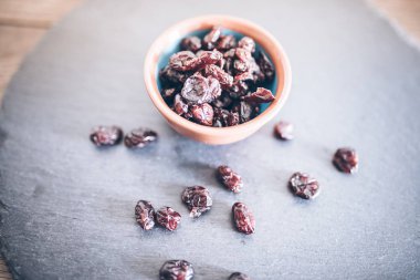 dried cranberries in bowl on slate