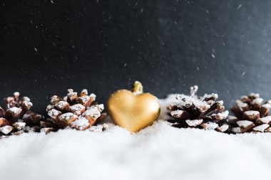 karlı kış Noel dekorasyonu altın kalpli Noel ağaç süsleme ve çam kozalakları şeklinde.