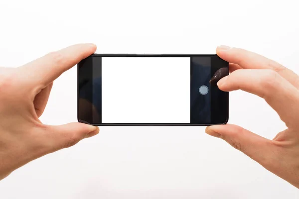 Zwei männliche Hände, die ein Smartphone horizontal halten, um ein Foto isoliert auf weiß zu machen — Stockfoto