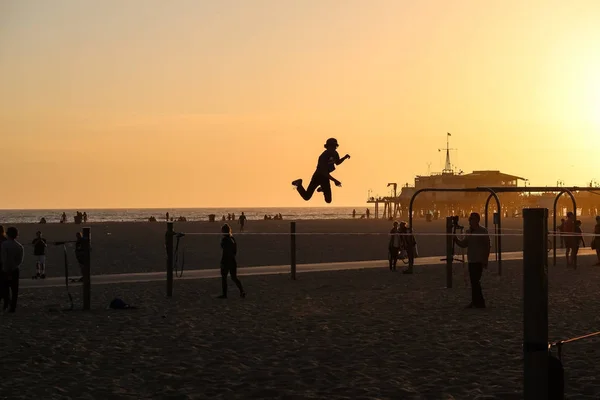Santa Monica, California, Usa 04.01.2017 slackline skoki osoby podczas zachodu słońca na plaży — Zdjęcie stockowe