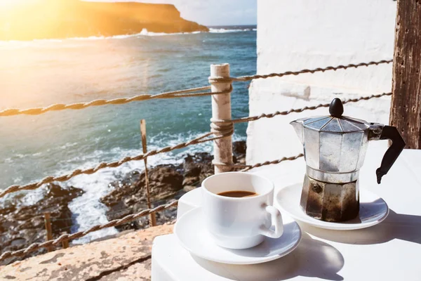 Moka pot espresso makinesi ve kahve kıyı şeridi ve okyanus arka planda tablo