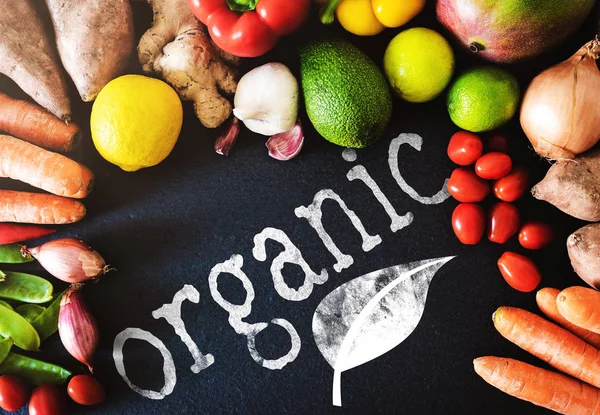 Directamente encima del primer plano de las verduras y frutas orgánicas frescas sobre el fondo de pizarra con la palabra ORGÁNICA — Foto de Stock