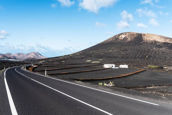 Estrada de asfalto através da paisagem vulcânica em Lanzarote, Ilhas Canárias — Fotografia de Stock