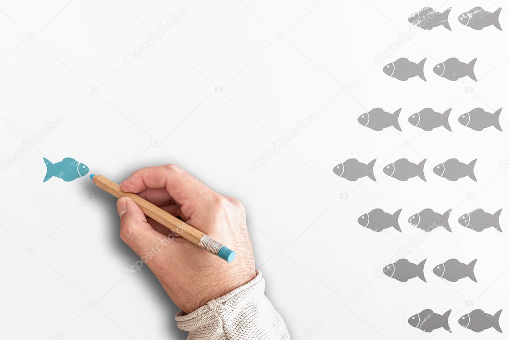 standing out from the crowd or leadership concept with group of fishes