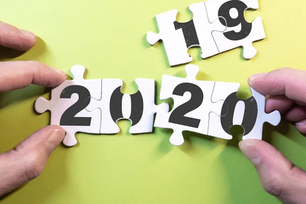 Koncepcja nowego roku z rękami zastępującymi puzzle na lata 2019-2020 — Zdjęcie stockowe