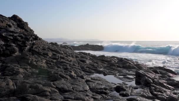 Littoral rocheux contre la mer agitée et ciel doré clair sur Lanzarote — Video