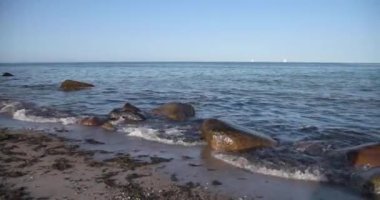 Heiligenhafen 'de sakin deniz ve mavi gökyüzüne karşı boş sahil