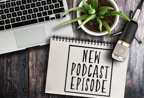 Podcast recording equipment on rustic wooden table with words new podcast episode written on note pad — Stock Photo, Image