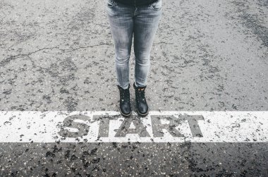 Asfalt yolda başlangıç çizgisinde duran kadının yüksek açılı görüntüsü