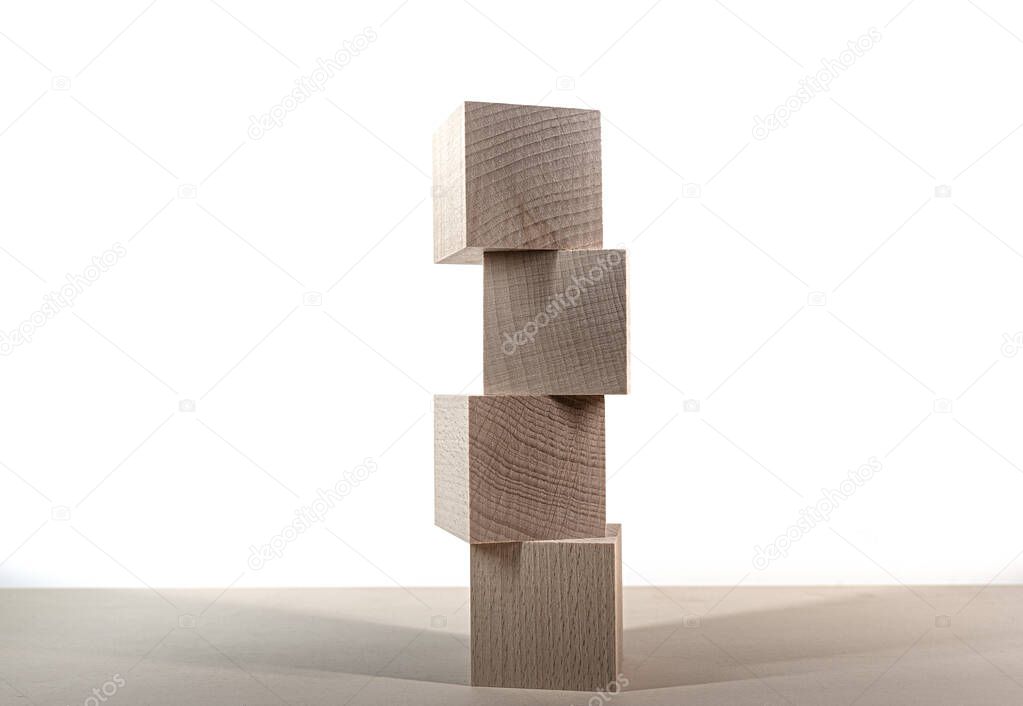 tower of four wooden blocks on table against white background