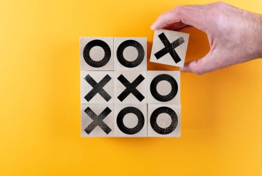 Tahta oyuncak bloklarında turuncu arka planda tic tac toe oyununun en üst görüntüsü