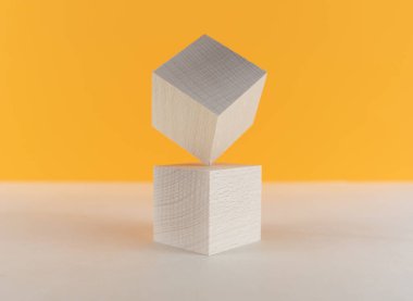 Bir köşesinde dengede duran tahta küpler, diğerinin tepesinde.