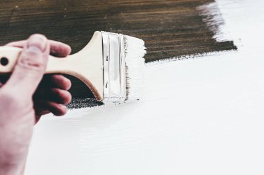 Odun boyamak için fırça kullanılıyor.