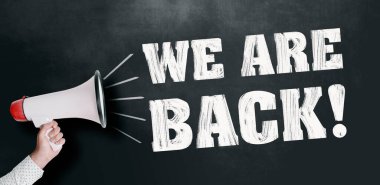 Karatahtaya karşı elinde megafonla geri döndüğümüz mesajını tutan kişi