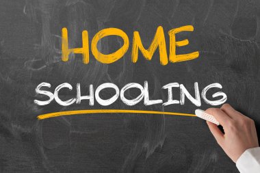 El ele tutuşan tebeşir karatahtaya karşı.