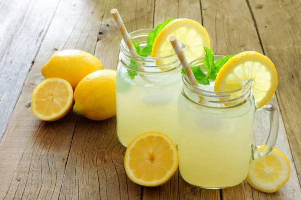 Dos vasos de tarro de albañil de limonada sobre madera rústica — Foto de Stock