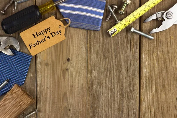 Happy Fathers Day tag with corner border of tools and ties on rustic wood