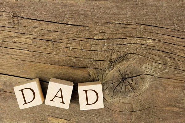 Wooden blocks spelling DAD on rustic wood — Stock Photo, Image