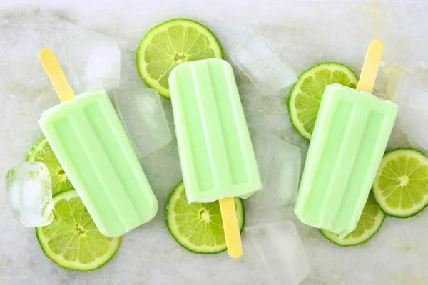 Lime yoghurt popsicles på vit marmor bakgrund — Stockfoto