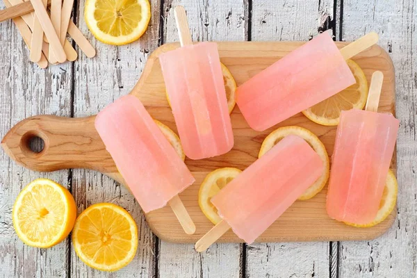 Rosa lemonad popsicles paddla ombord med wood bakgrund — Stockfoto