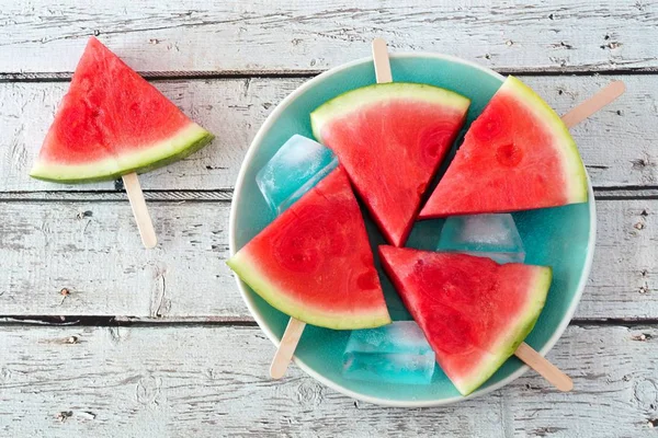 Watermeloen segment knalt op blauw bord met rustieke houten achtergrond — Stockfoto